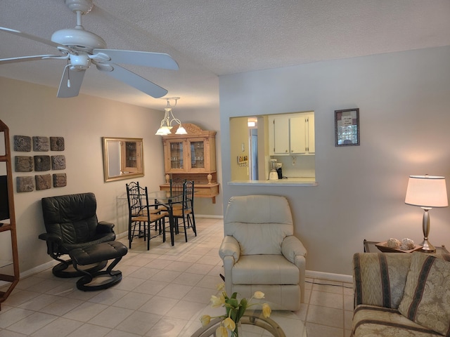 living room with ceiling fan and a textured ceiling