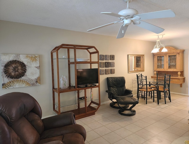 living room with ceiling fan with notable chandelier and a textured ceiling