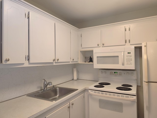 kitchen featuring white cabinetry, sink, and white appliances