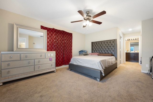 bedroom featuring light colored carpet, ceiling fan, and ensuite bathroom