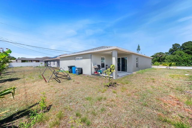 rear view of house featuring a lawn