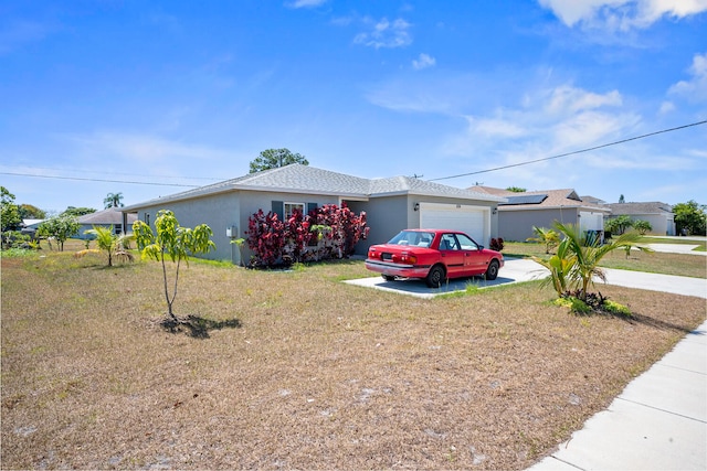 ranch-style home featuring a garage and a front lawn