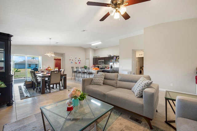 tiled living room featuring lofted ceiling and ceiling fan with notable chandelier