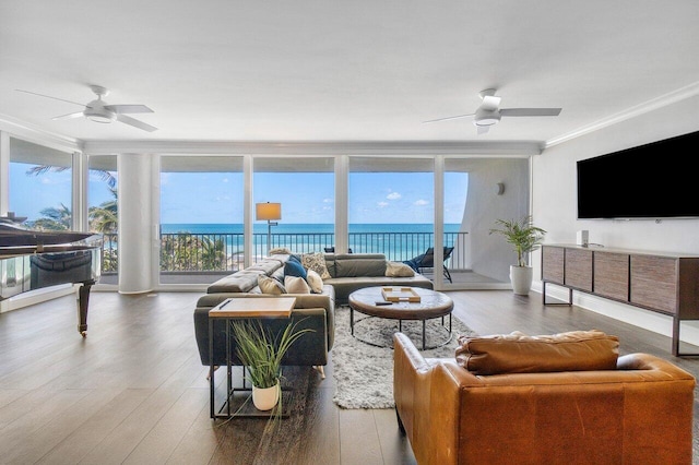 living room featuring crown molding, dark wood-type flooring, a water view, floor to ceiling windows, and ceiling fan