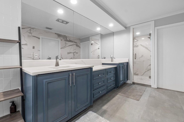 bathroom with a shower, oversized vanity, dual sinks, and tile walls