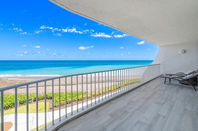 balcony featuring a beach view and a water view