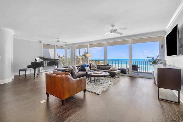 living room featuring expansive windows, a water view, ceiling fan, hardwood / wood-style flooring, and ornamental molding