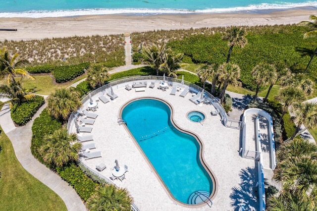 view of pool featuring a water view and a beach view