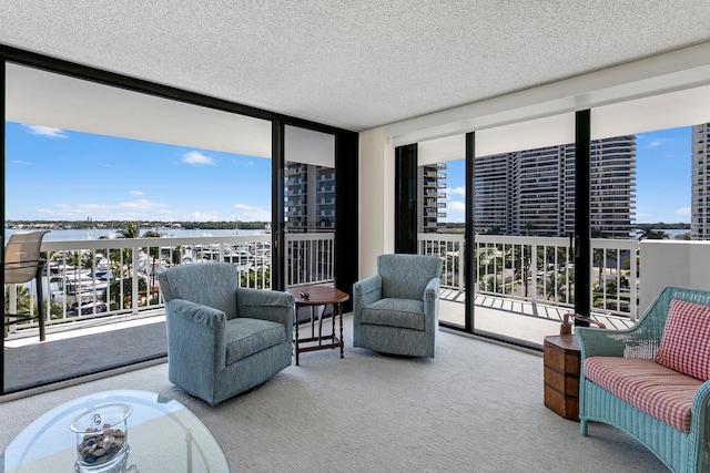 living room with a textured ceiling, carpet flooring, and floor to ceiling windows