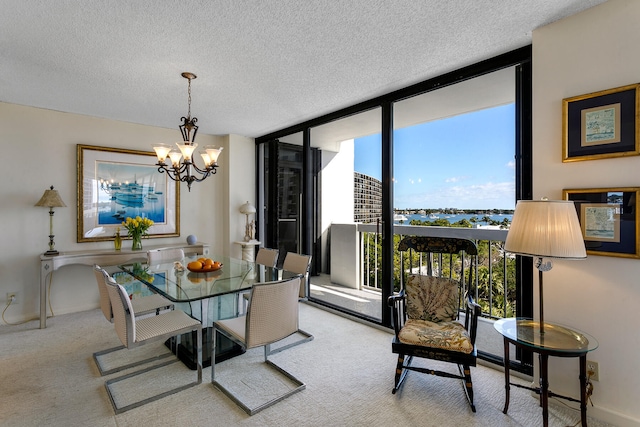 carpeted dining room featuring a textured ceiling, floor to ceiling windows, and an inviting chandelier