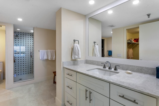 bathroom with vanity, toilet, and tiled shower