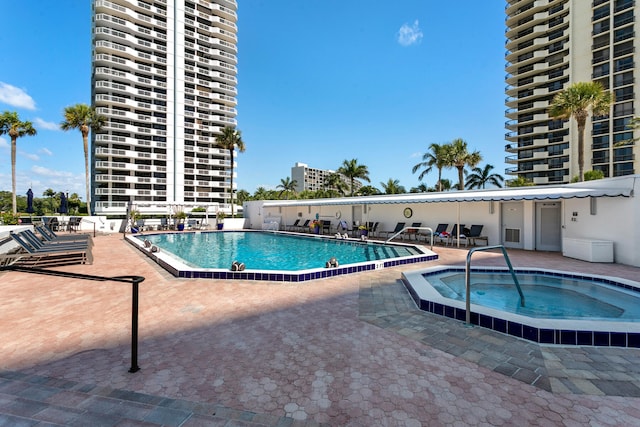 view of pool with a patio area and a hot tub