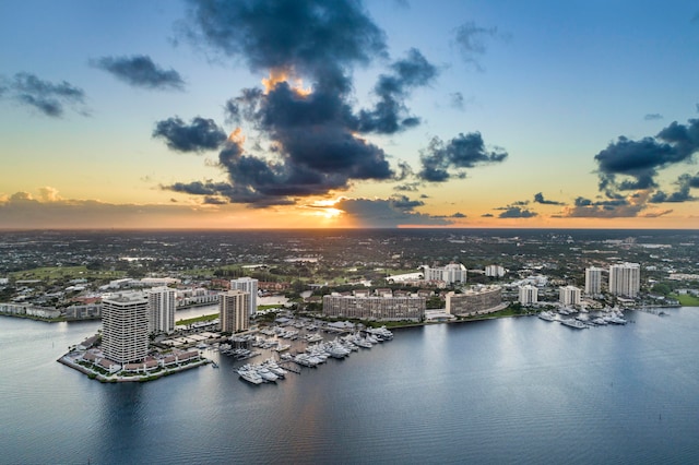 aerial view at dusk featuring a water view