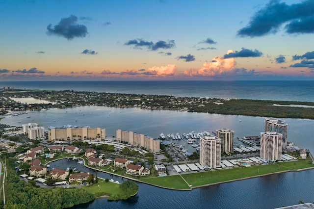 aerial view at dusk featuring a water view