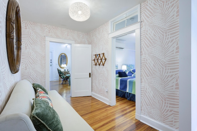 bedroom featuring a wall mounted AC and dark hardwood / wood-style flooring