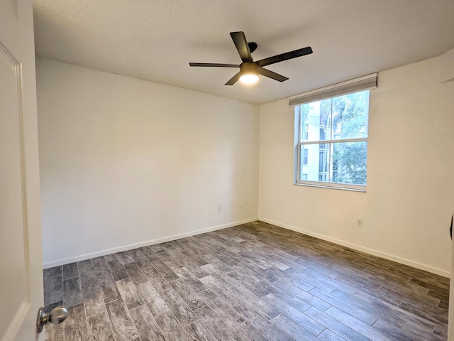 spare room with dark hardwood / wood-style flooring, a textured ceiling, and ceiling fan