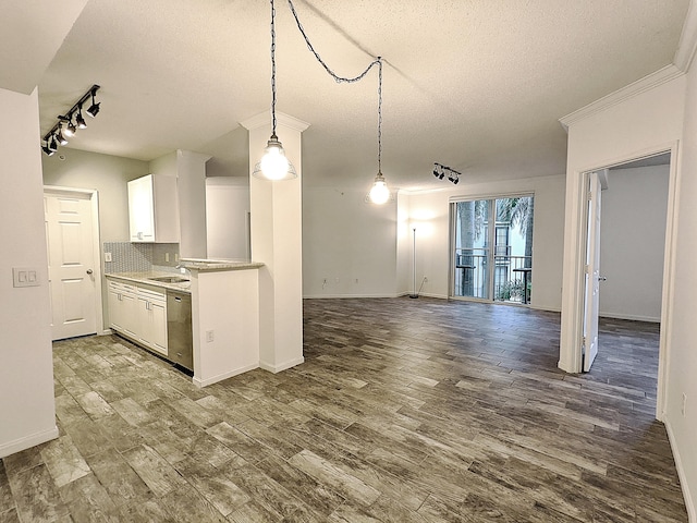 kitchen with sink, hardwood / wood-style flooring, white cabinetry, backsplash, and decorative light fixtures