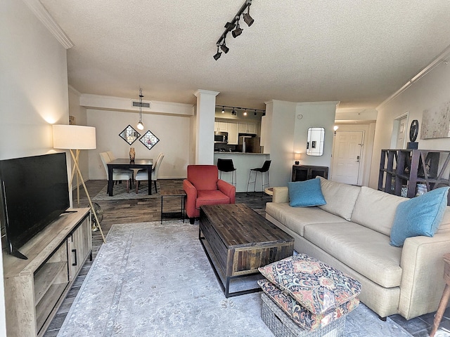 living room with crown molding, wood-type flooring, and a textured ceiling