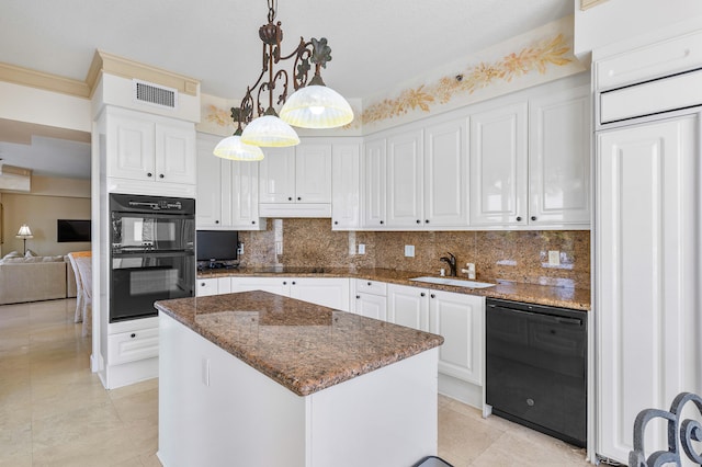 kitchen featuring backsplash, a kitchen island, black appliances, white cabinets, and pendant lighting