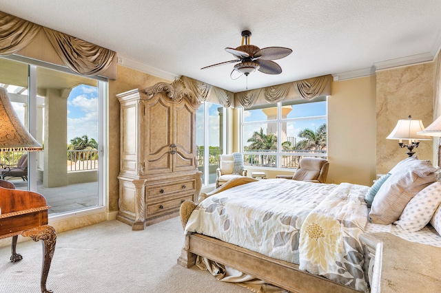 bedroom with ceiling fan, carpet, a textured ceiling, access to exterior, and crown molding