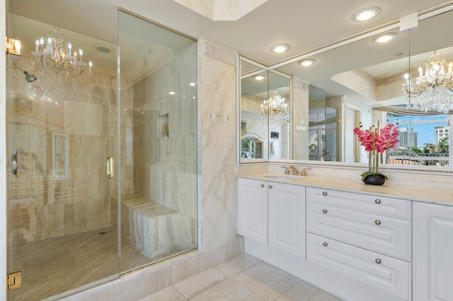 bathroom with a raised ceiling, tile floors, a shower with shower door, vanity, and an inviting chandelier