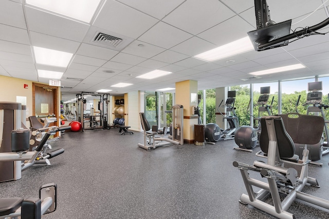 workout area with a drop ceiling and a healthy amount of sunlight