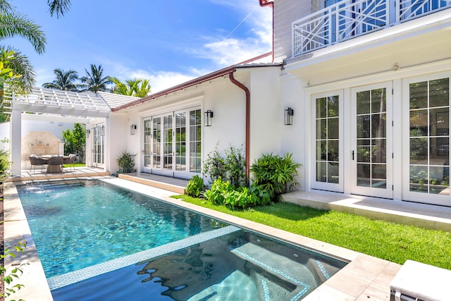 view of swimming pool with a patio, french doors, and an in ground hot tub