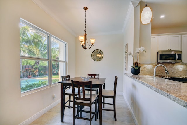 tiled dining room featuring crown molding and a chandelier