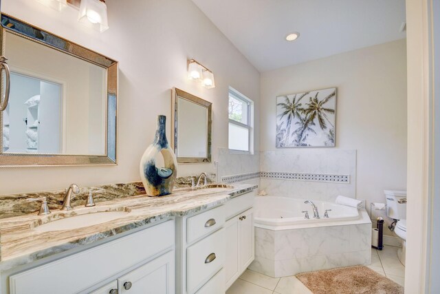 bathroom with vanity, tiled tub, tile patterned floors, and toilet