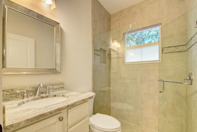 bathroom with toilet, a shower with door, and vanity