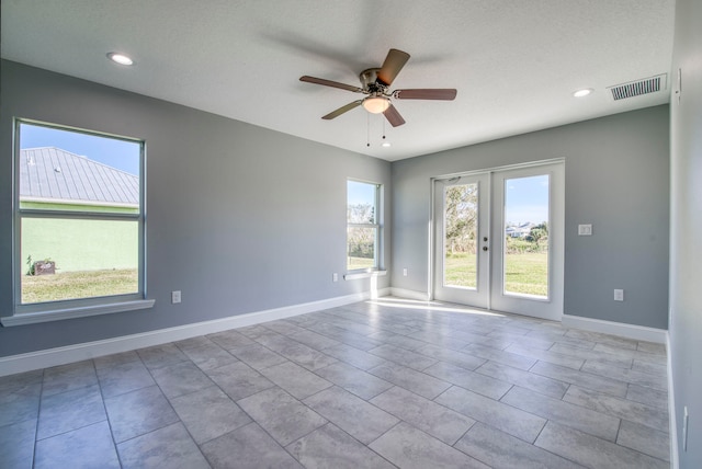 tiled spare room featuring french doors, a textured ceiling, and ceiling fan