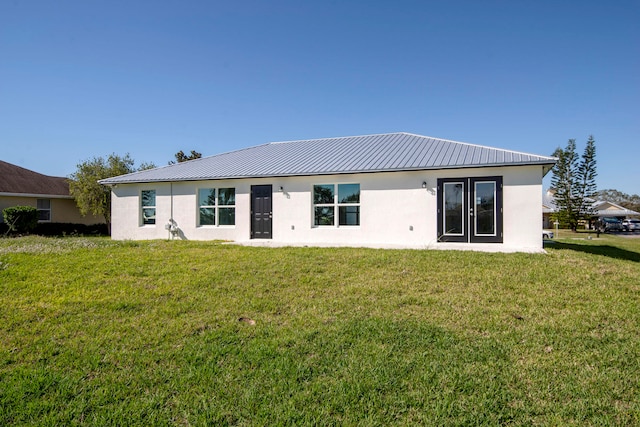 rear view of house featuring a yard