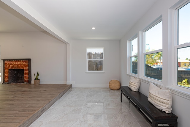 sitting room with light tile flooring, a healthy amount of sunlight, and a fireplace