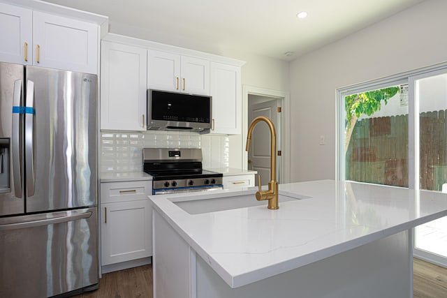 kitchen featuring tasteful backsplash, dark hardwood / wood-style floors, stainless steel appliances, and white cabinetry