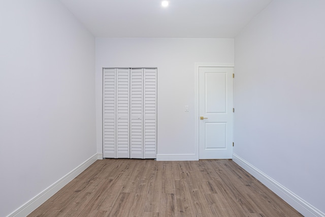 unfurnished bedroom with a closet and light wood-type flooring