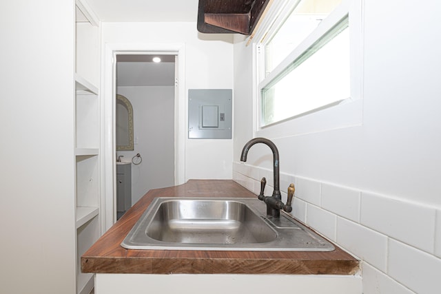 kitchen with white cabinets, sink, tasteful backsplash, and wood counters