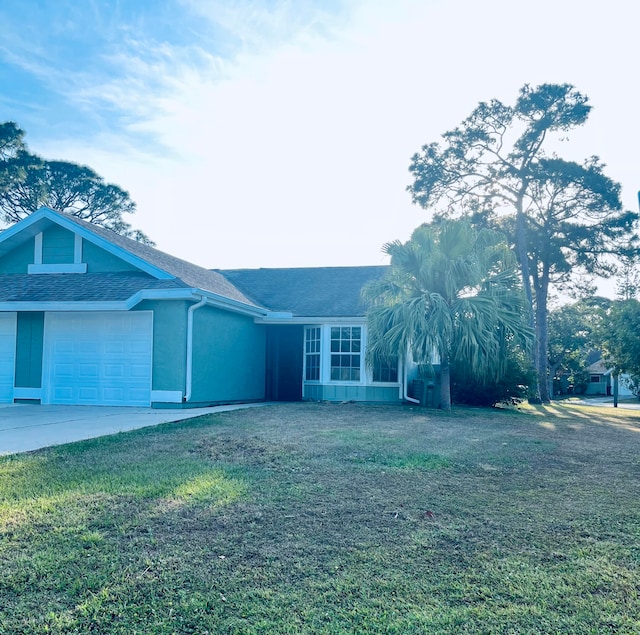 single story home featuring a front lawn and a garage