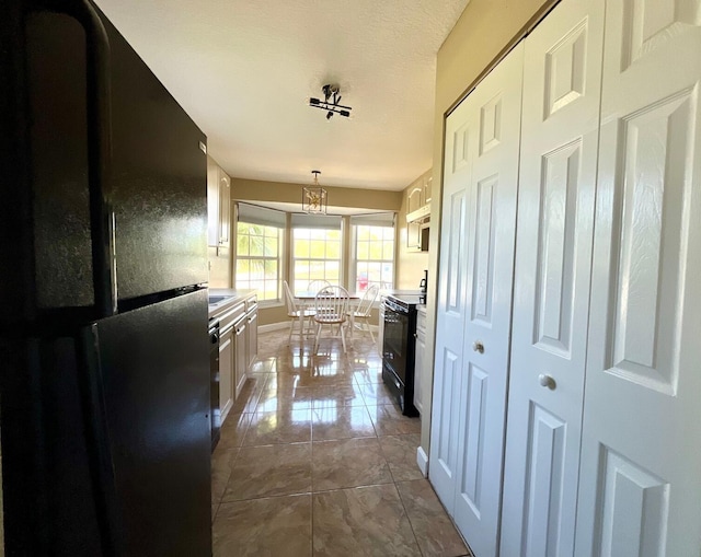 kitchen with hanging light fixtures, dark tile flooring, and black appliances