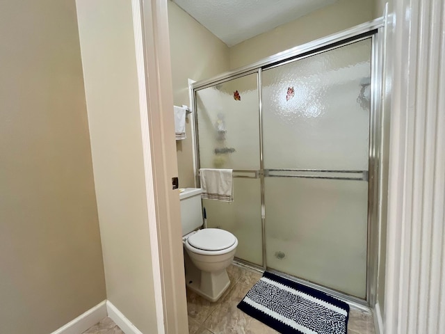 bathroom featuring a shower with door, toilet, tile flooring, and vanity