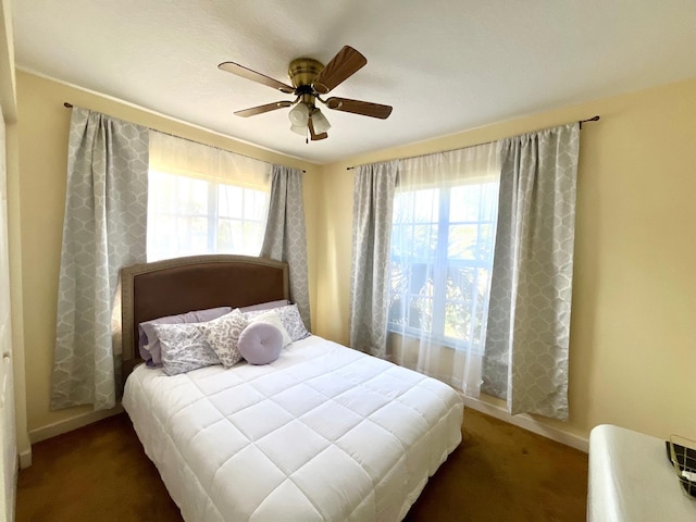 carpeted bedroom featuring ceiling fan and multiple windows