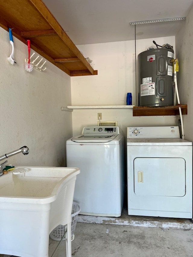 washroom featuring water heater, sink, washer hookup, and washer and clothes dryer