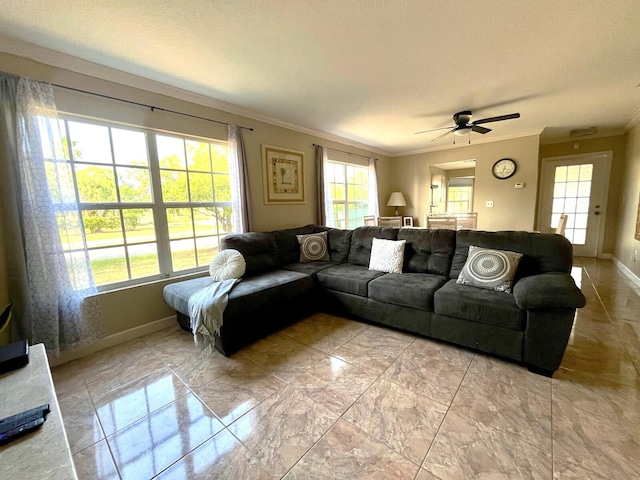 tiled living room featuring plenty of natural light, crown molding, and ceiling fan