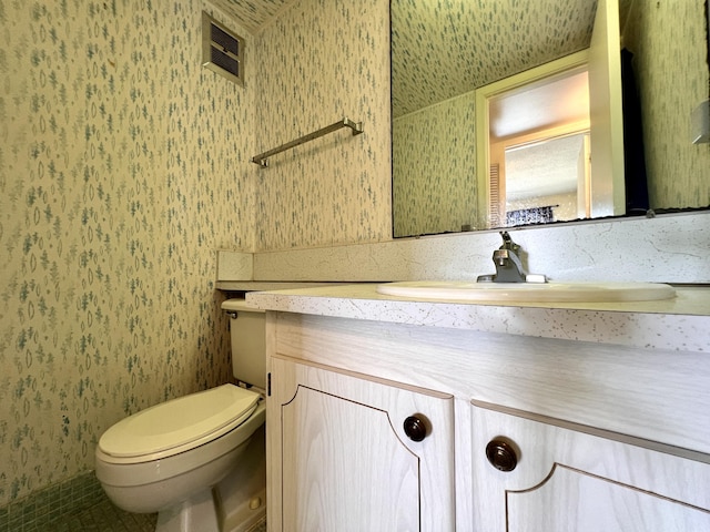 bathroom featuring tile patterned flooring, vanity, and toilet