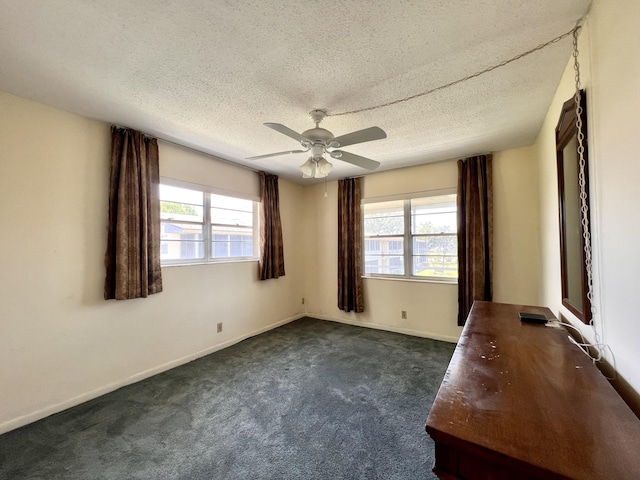 carpeted spare room with ceiling fan and a textured ceiling