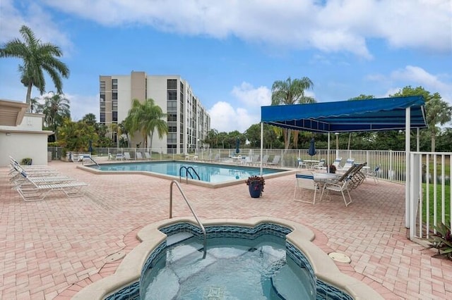 view of swimming pool featuring a community hot tub and a patio