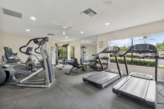 workout area with ceiling fan and a textured ceiling