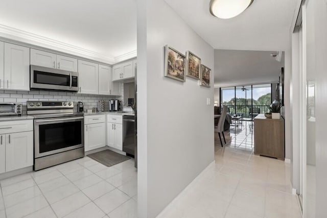 kitchen featuring backsplash, stainless steel appliances, white cabinetry, and light tile floors