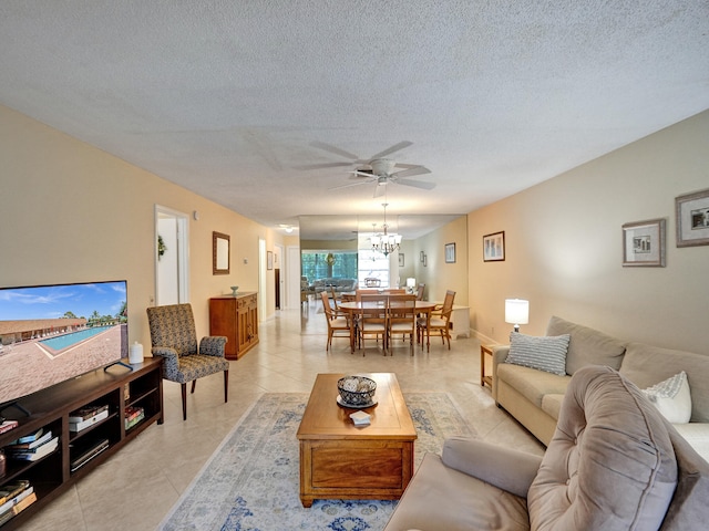 living room featuring ceiling fan, light tile patterned flooring, and a textured ceiling