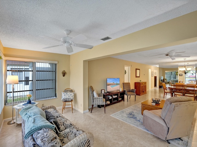 bedroom with ceiling fan, light tile patterned flooring, and a textured ceiling