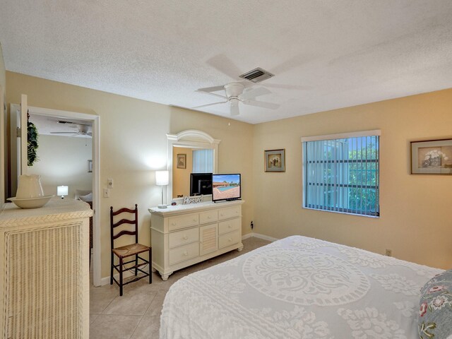 bathroom featuring tile patterned flooring, a textured ceiling, vanity, and toilet